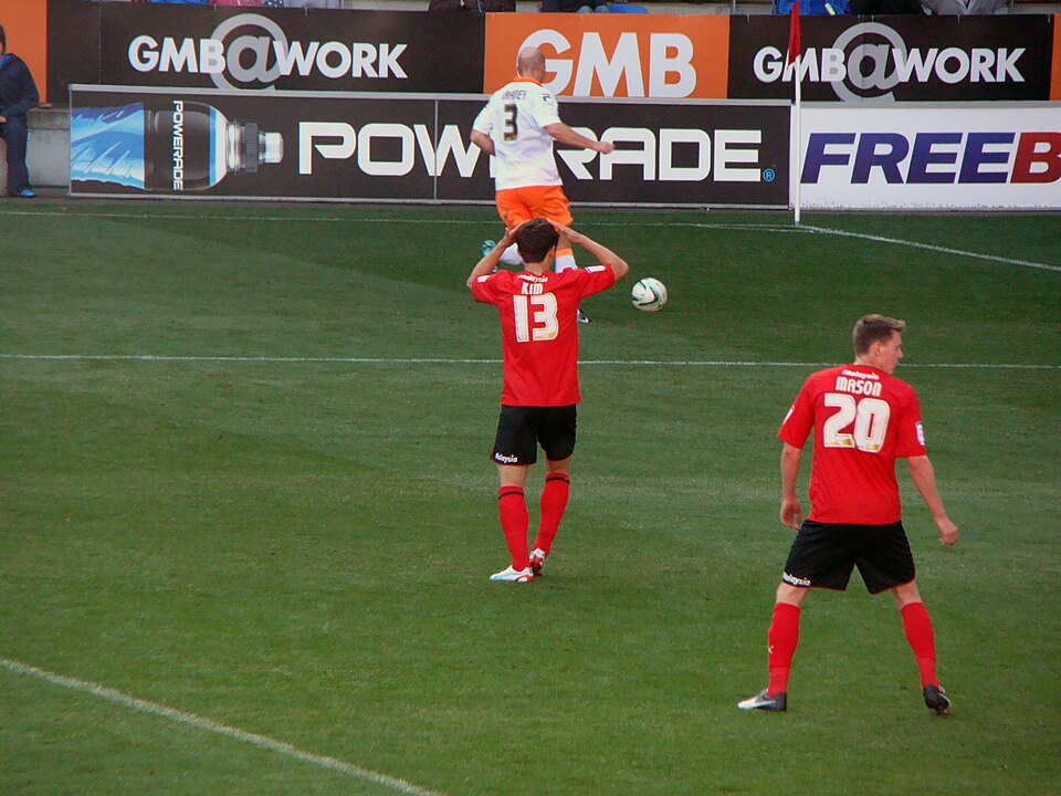 Hinchas viendo un partido intenso en un bar deportivo durante la noche